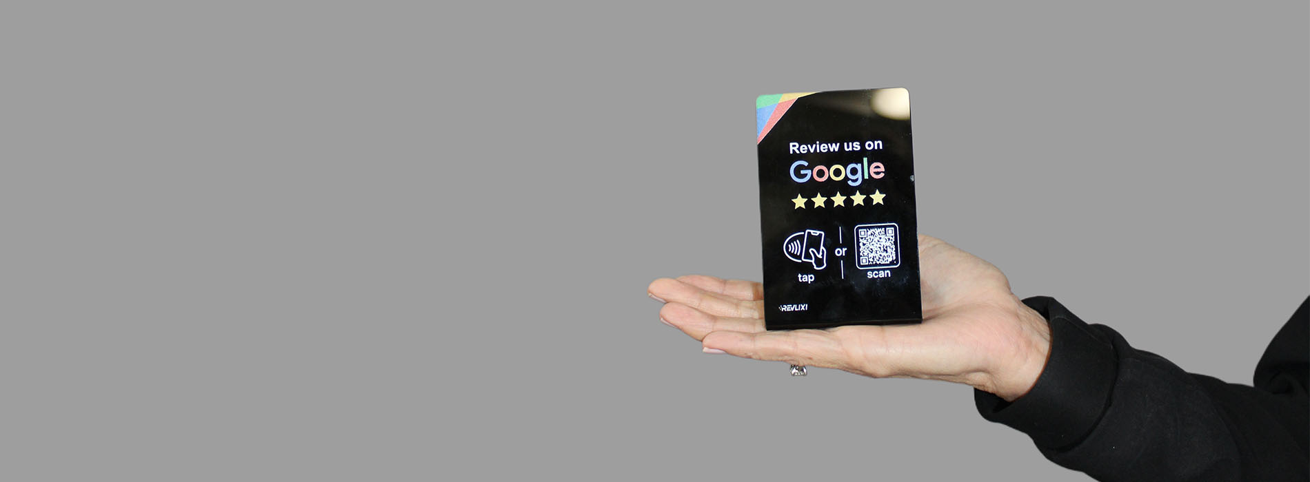 The image shows a hand holding a tablet with a star rating graphic on the screen, indicating high customer satisfaction or approval.