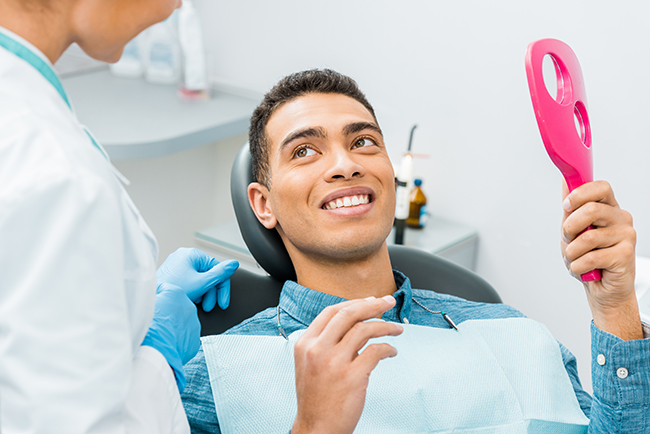 The image depicts a dental professional with a patient in a dental chair, both smiling.